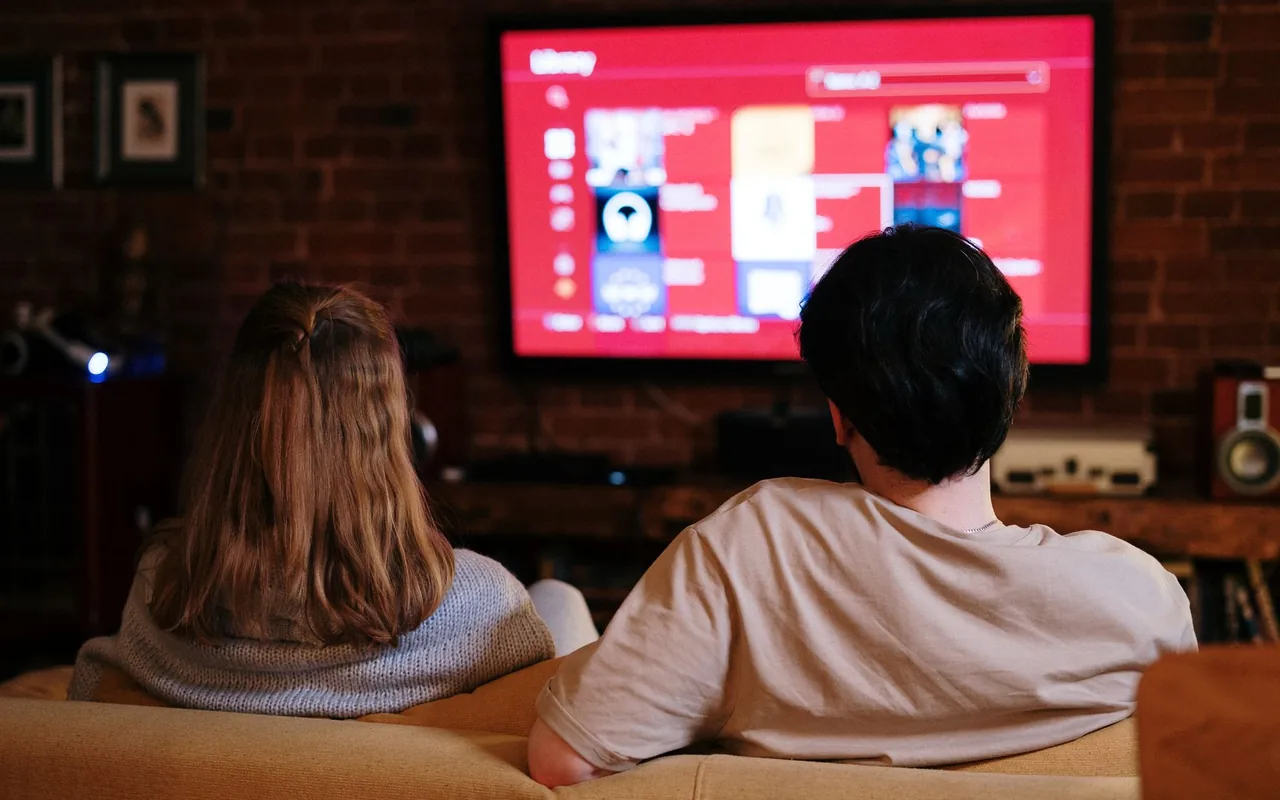Couple watching IPTV Stream on a large TV in a cozy living room